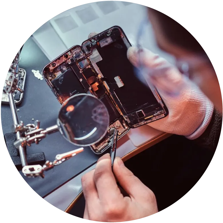 Technician repairing an iPhone by seeing through magnifying glass